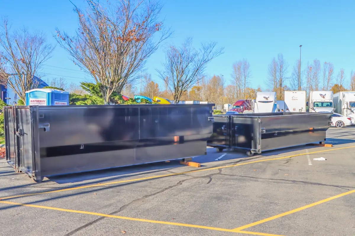 Professional dumpster rental service with roll-off container on residential driveway in Rexburg